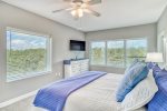 Master bedroom with a king bed, flat screen TV and beautiful nature preserve views